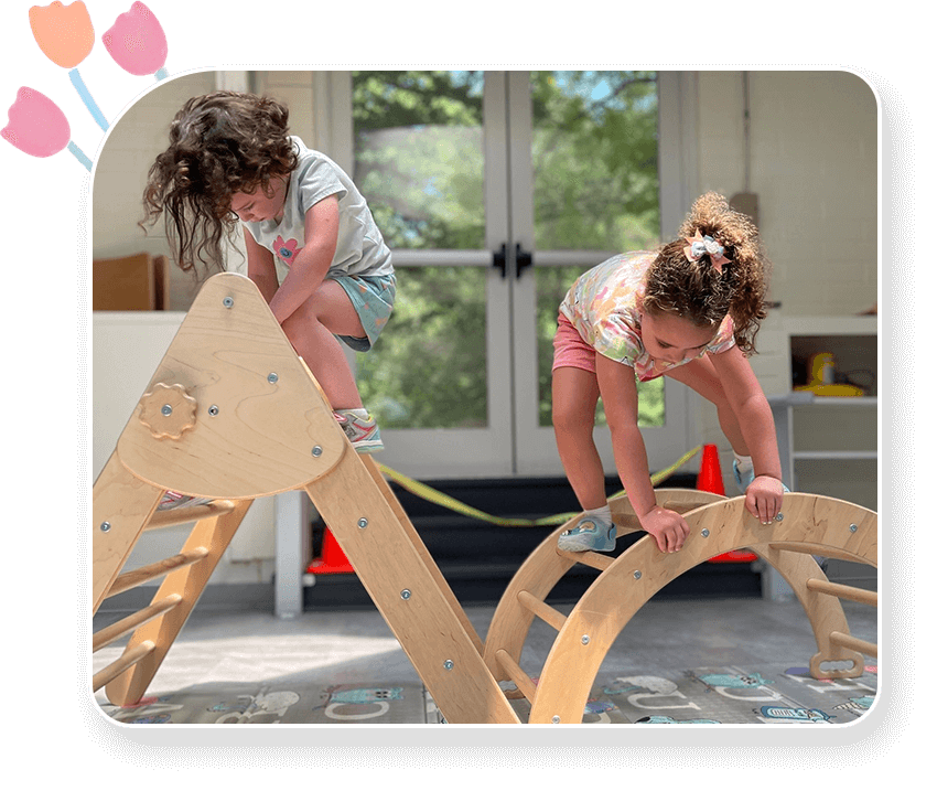 Two young girls are playing on a wooden horse.