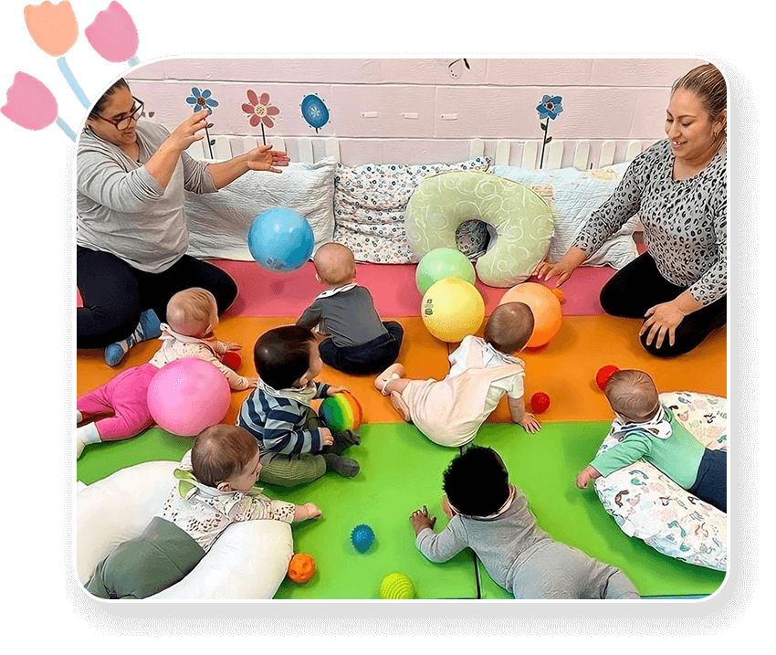 A group of babies playing with balls on the floor.