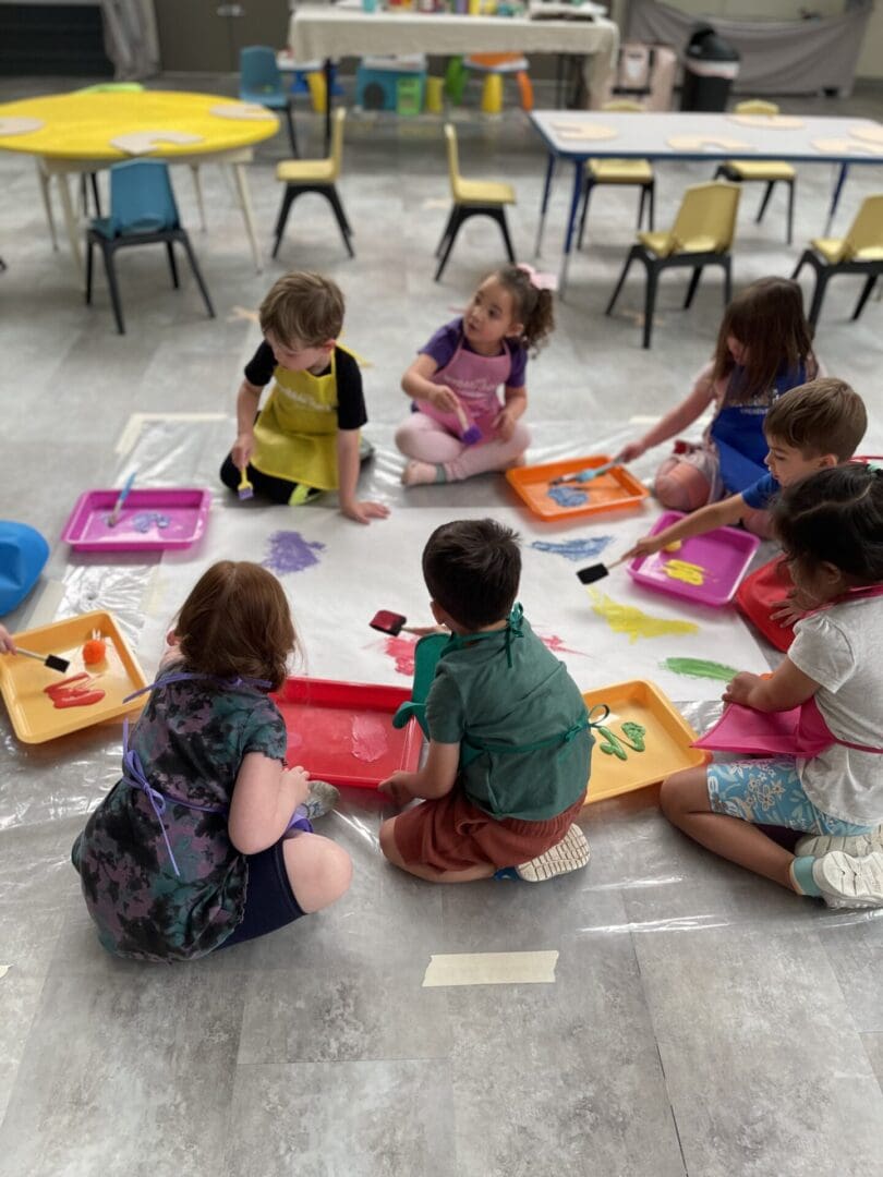 A group of children sitting on the floor playing with toys.